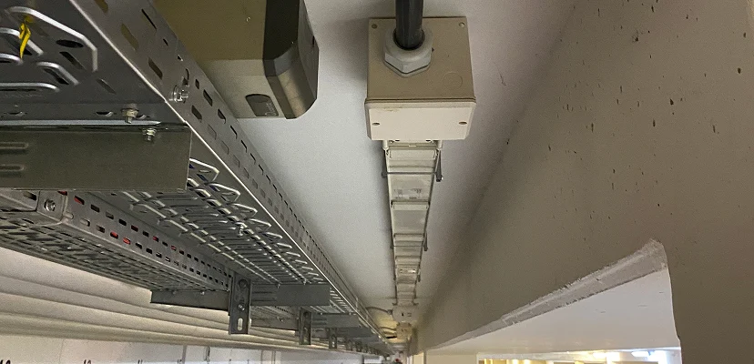 Metallene Kabeltrasse mit verlegten Leitungen und Abzweigdosen an der Decke eines Technikraums