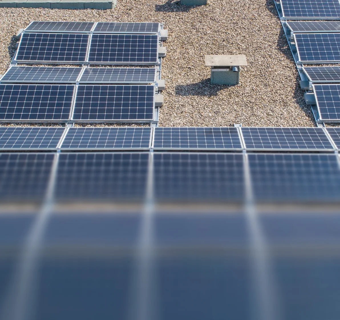 Photovoltaikanlage mit mehreren Solarmodulen auf einem Flachdach mit Kiesbelag